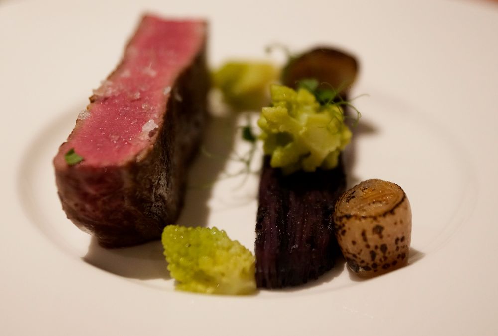 Medium-rare Steak mit Gemüse auf weißem Teller