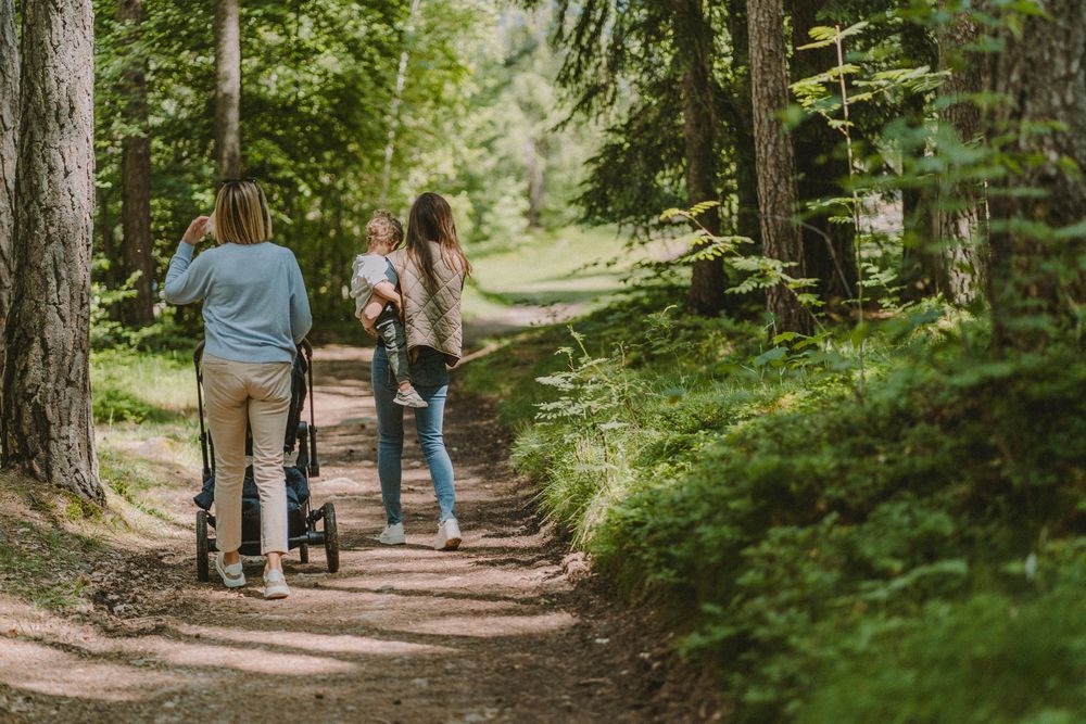 Zwei Frauen mit Kindern auf einem Waldweg.