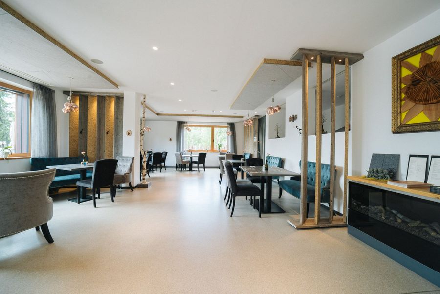 Helles, modern eingerichtetes Restaurant mit Tischen, Stühlen und großen Fenstern