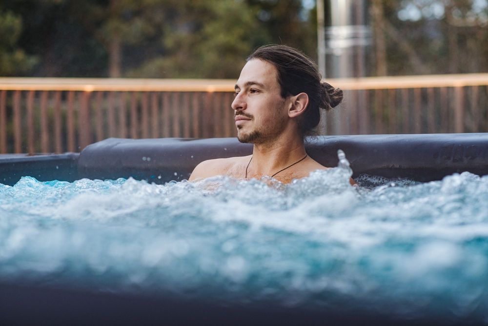 Mann entspannt sich im sprudelnden Whirlpool im Freien