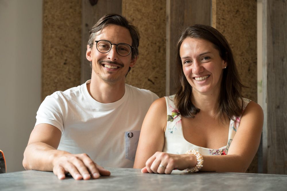 Smiling man and woman sitting together at a table indoors.